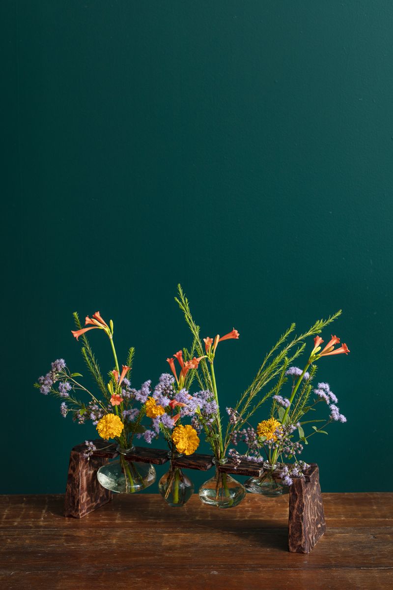 Set of four glass budvases hanging from a mango wood platform..