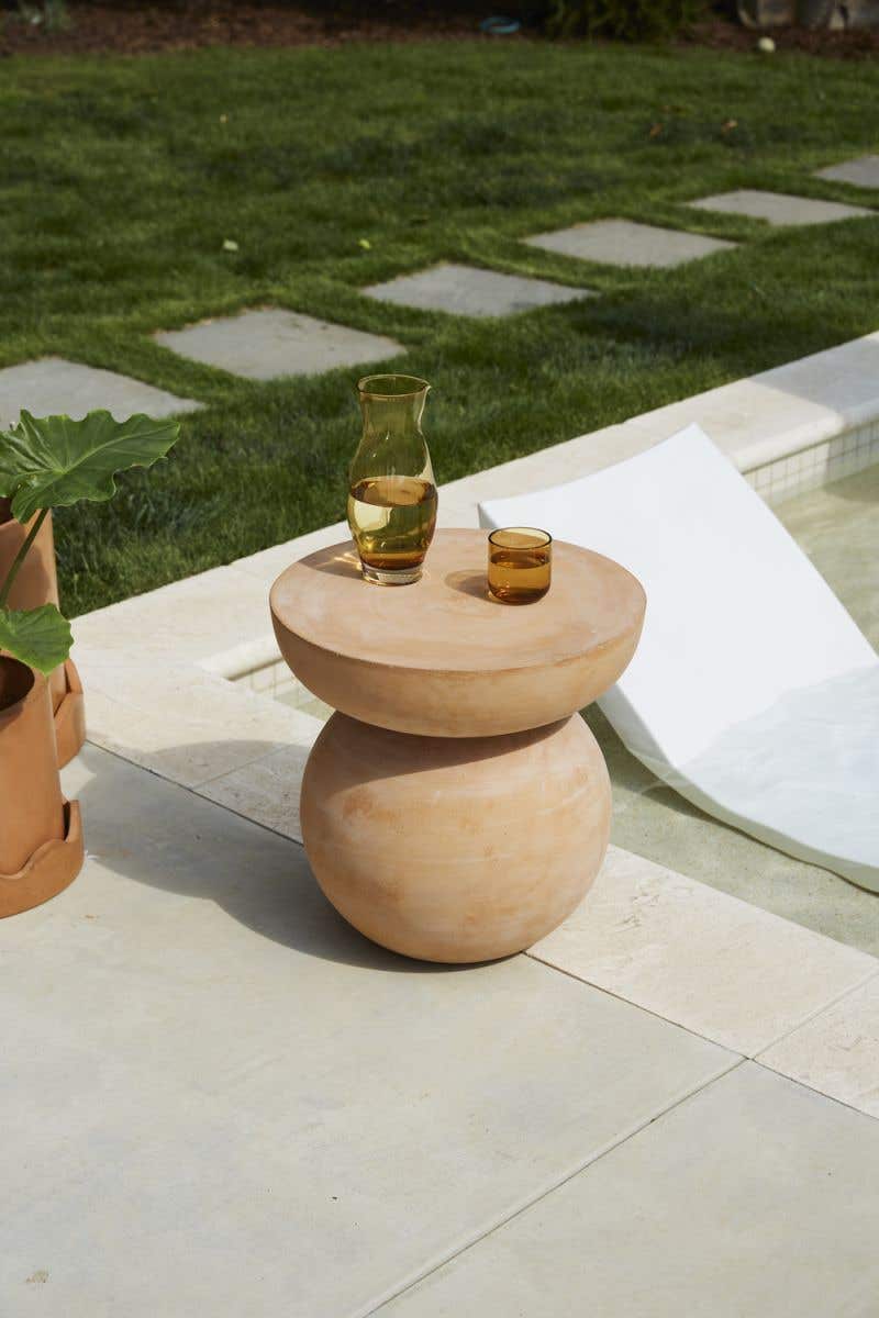 Outdoor stool sphere base & a half-sphere top that offers a flat surface finished in warm terracotta