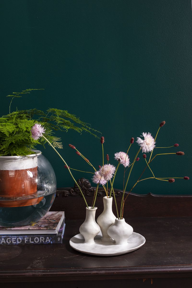 A budvase trio finished in glazed white ceramic on an attached white tray.