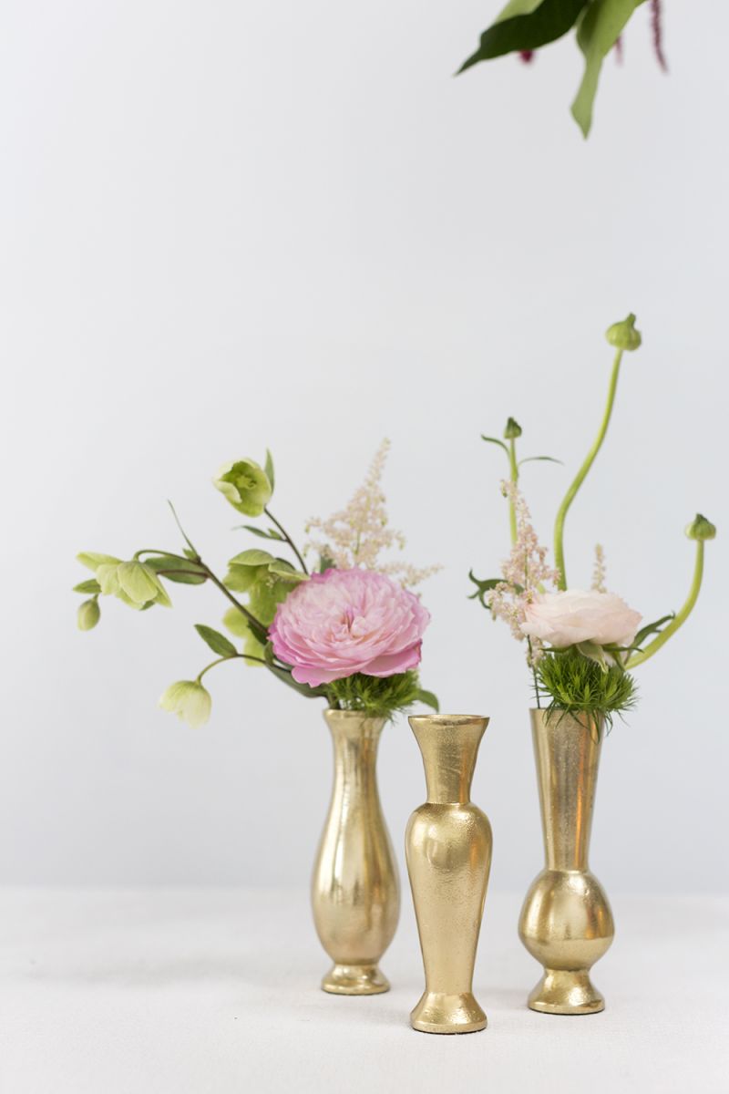 Set of three gold bud vases offers three different shapes and has a brushed gold finish