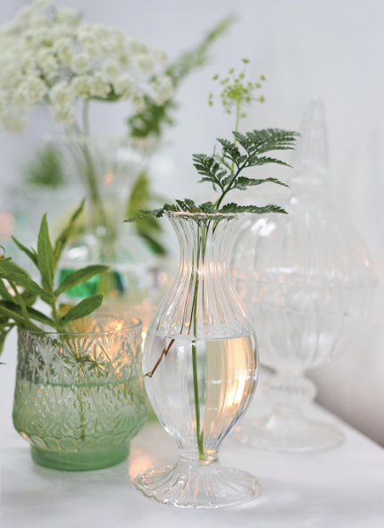 Ribbed glass budvases in two fluted shapes.