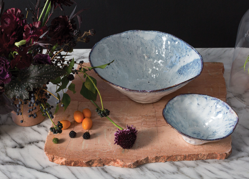 Vessel has a wavy rim and irregular sanded glaze with purple, iridescent and blue tones.