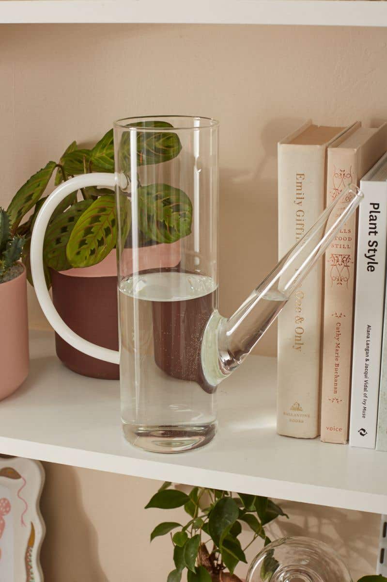 Delicate glass watering can with white glass handle and elegant spout makes a perfect decorative or useful piece for every floral design.