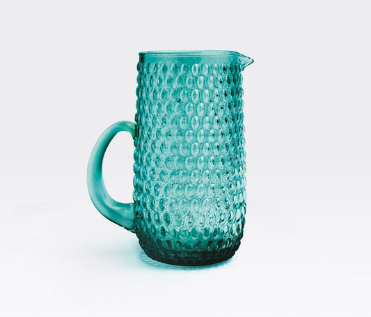 cylindrical Claire evokes the serve ware of eras past—a modern update on a vintage classic. Oval-shaped beads add texture to the pitcher while a smooth handle makes for a sturdy hold.