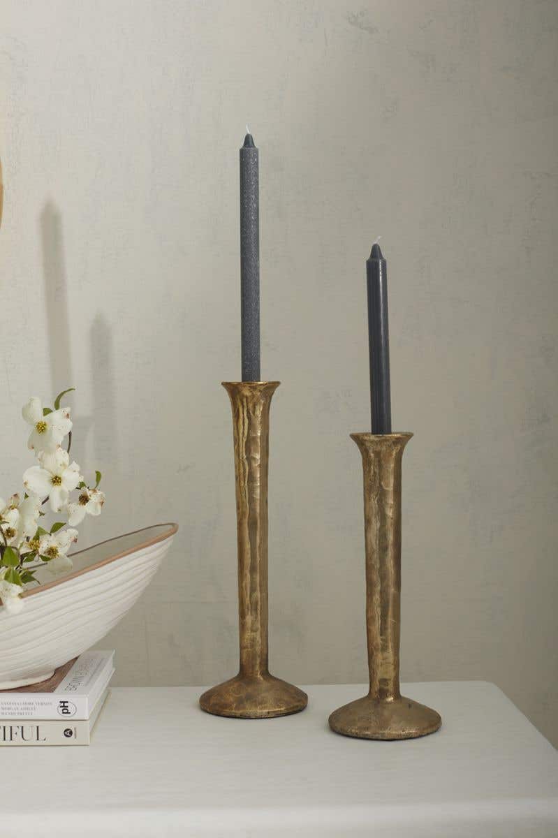 spool-shaped metal candle holder is made from polyresin with a mottled gold finish