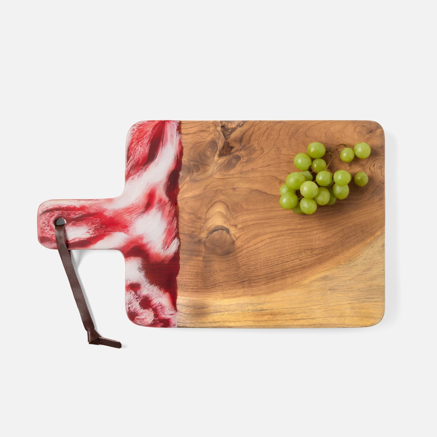 Teak board and resin handle are combined to create a one of a kind serving board. The handle is two-toned and hand-dipped in a berry color. Finished with a leather strap.