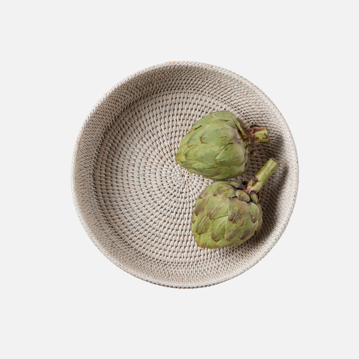 Footed, rattan pedestal bowl with artichokes displayed